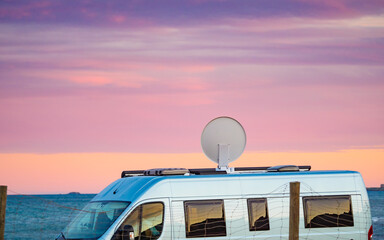 Caravan by sea with satellite dish on roof
