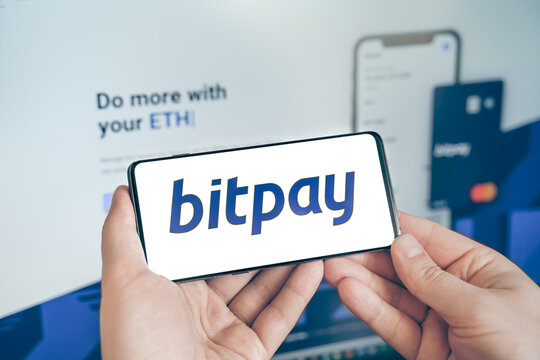 Russia Moscow 19.01.2022 Logo of Bitpay cryptocurrency wallet. Businessman with mobile phone, laptop. Blockchain application to buy, store ,send, swap crypto coins, digital tokens