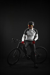 Obraz na płótnie Canvas male cyclist with road bicycle on black background
