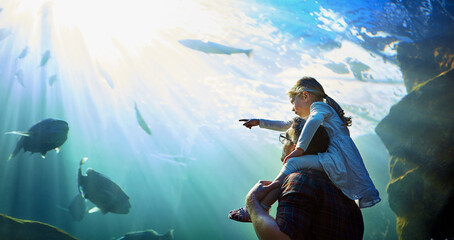 What is the name of that fish Dad. Cropped shot of a father and his little daughter looking at an...