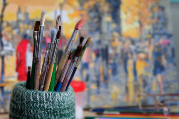 Bunch of painting brushes on a beautiful colorful background of a painting.