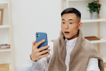 handsome man home with smartphone in chair interior internet