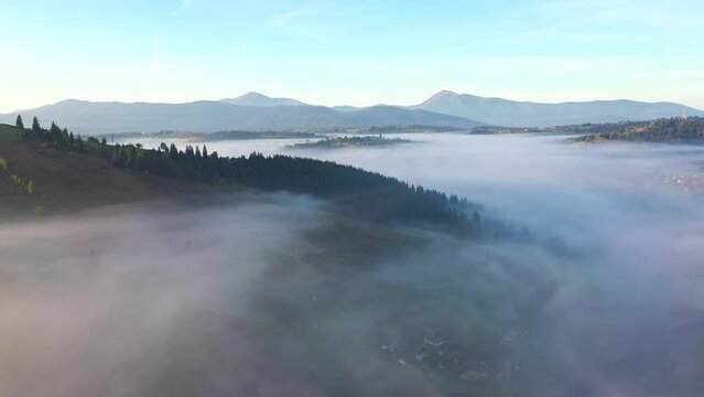 Tranquil rural landscape is covered with thick fog from a bird's eye view. Filmed in UHD 4k video.