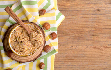Raw Organic Ground Hazelnut Flour in a Bowl with whole nuts on rustic wooden background. Alternative nut flour for keto diet and gluten free food. Paleo and ketogenic diet baking cooking concept above