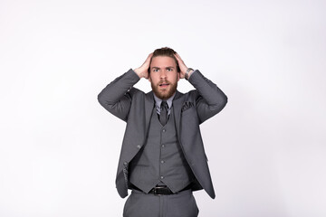 Young businessman in gray elegant suit hands on head having troubles and headache