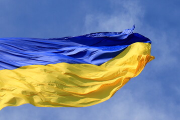 Ukraine flag large national symbol fluttering in sky. Large yellow blue Ukrainian state patriotic flag