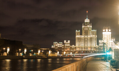 Fototapeta premium Moscow, Russia. Night view of skyscraper building at Kotelnicheskaya embankment, Shot from Raushskaya embankment. February