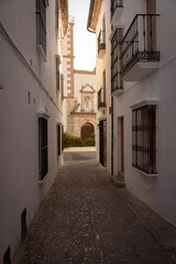 Fototapeta na wymiar Street in the old town in the white village of Grazalema with the parish of the incarnation in the background, Natural Park of Grazalema mountain range, Cadiz, Andalusia, Spain