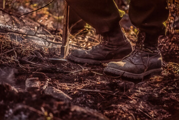 A wildland firefighter's boots on smoldering terrain