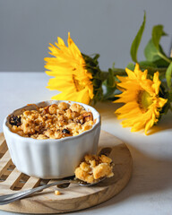 Apples with crumble and cinnamon. Fall time. Autumn dessert. Yellow sunflowers.