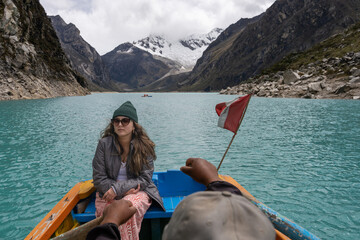girl riding in a rowing boat on a lagoon between mountains
