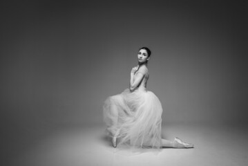 black-and-white photo, young pretty, fragile, beautiful ballerina dancing in a long pale pink dress...