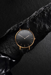 Luxurious gold watch with a black dial. A watch on a beautiful black background with black stones....