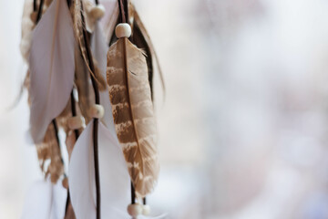 close up of dreamcatcher, grey and white leathers