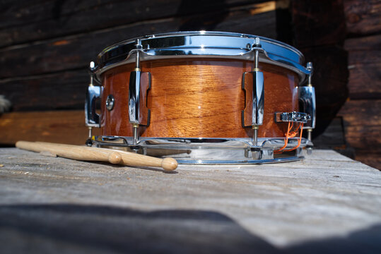 Snare drum with drumsticks on a wooden ground