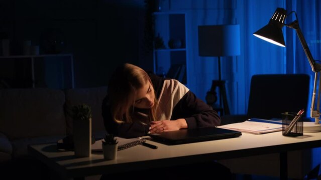 Tired sleepy young woman falling asleep at work desk after ending work