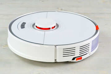 Fototapeta premium robot vacuum cleaner on the wooden floor cleaning the room. Smart cleaning and washing technology. advanced robot work to vacuum then mop. close up