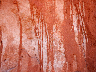Dripping red, pink and white patterns on a arroyo wall in the Bears Ears wilderness area of Southern