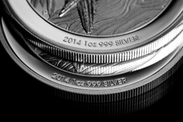 Close up of Silver Bullion Coin on a black mirror background