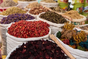 Variety organic pepper, flowers, hibiscus, herbs in sacks on sale on a farmers market.Traditional arabic market.