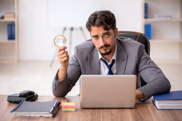 Young male employee sitting in the office