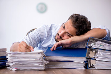 Young male employee and too much work in the office