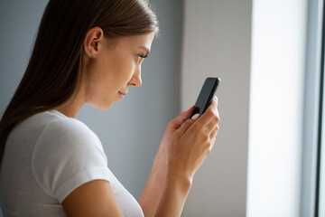 The young woman does not look away from the phone