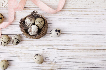 easter quail eggs and flowers on wooden background