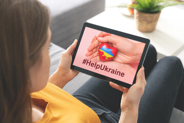 Hand holding a heart with Ukrainian national colors. Help Ukraine during the war