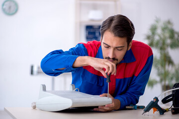 Young male repairman repairing heater