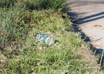 Abandoned Beer Can on the shoulder of a country road. Pollution of Nature Recycle the trash.