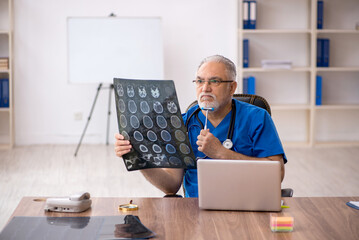 Old male doctor radiologist working in the clinic