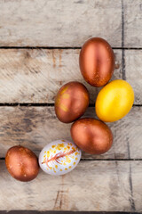 Colored Easter eggs and willow on  wooden background .