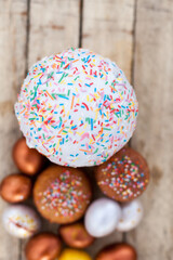Colored Easter eggs and willow on  wooden background .