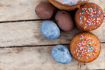 Colored Easter eggs and willow on  wooden background .