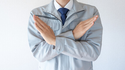 NGポーズ・作業服にネクタイの男性・建設業イメージ