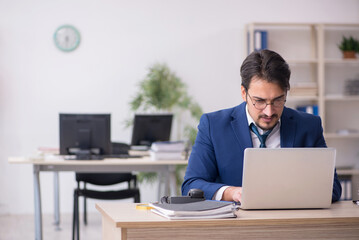 Young male employee unhappy with excessive work in the office