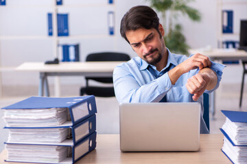 Young male employee and too much work in the office