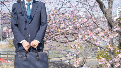 桜の花とスーツ姿の男性｜卒業・入社イメージ