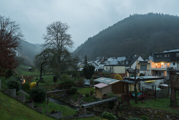 Kordel, Rhineland-Palatinate - Germany - 04 14 2019 - Foggy view over the backyards, gardens and traditional  houses in the Kyll valley of the small village at the German countryside