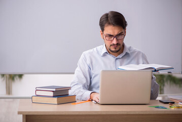 Young male teacher in front of whiteboard