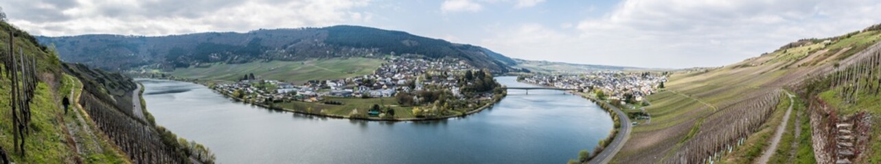 Fototapeta na wymiar Mehring, Rhineland- Palatinate - Germany - View over the village of Mehring with the meandering Moselle river surrounded by vineyards on the green hills