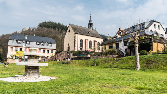 Auw An der Kyll, Rhineland-Palatinate - Germany - Scenic view over the church, square and small park of the village at the German countryside