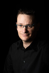 Portrait of a 42 year old business man, wearing a black shirt