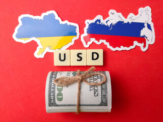 Top view banknotes,russia and ukraine flag with text USD on red background.