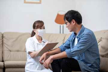 Obraz premium 問診票に記入する看護師と患者（マスクと手袋）