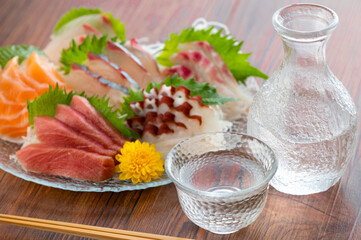 ガラスの皿に盛られた刺し身と日本酒