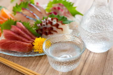 Fototapeta na wymiar ガラスの皿に盛られた刺し身と日本酒