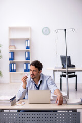 Young male employee suffering at workplace