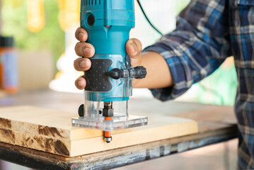 The carpenter building Furniture with electric trimmer